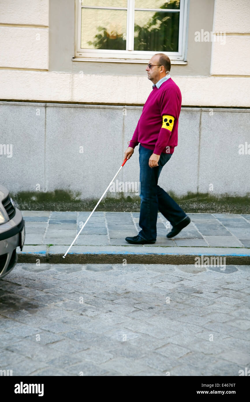A young woman helps a blind man cross the road Stock Photo Alamy