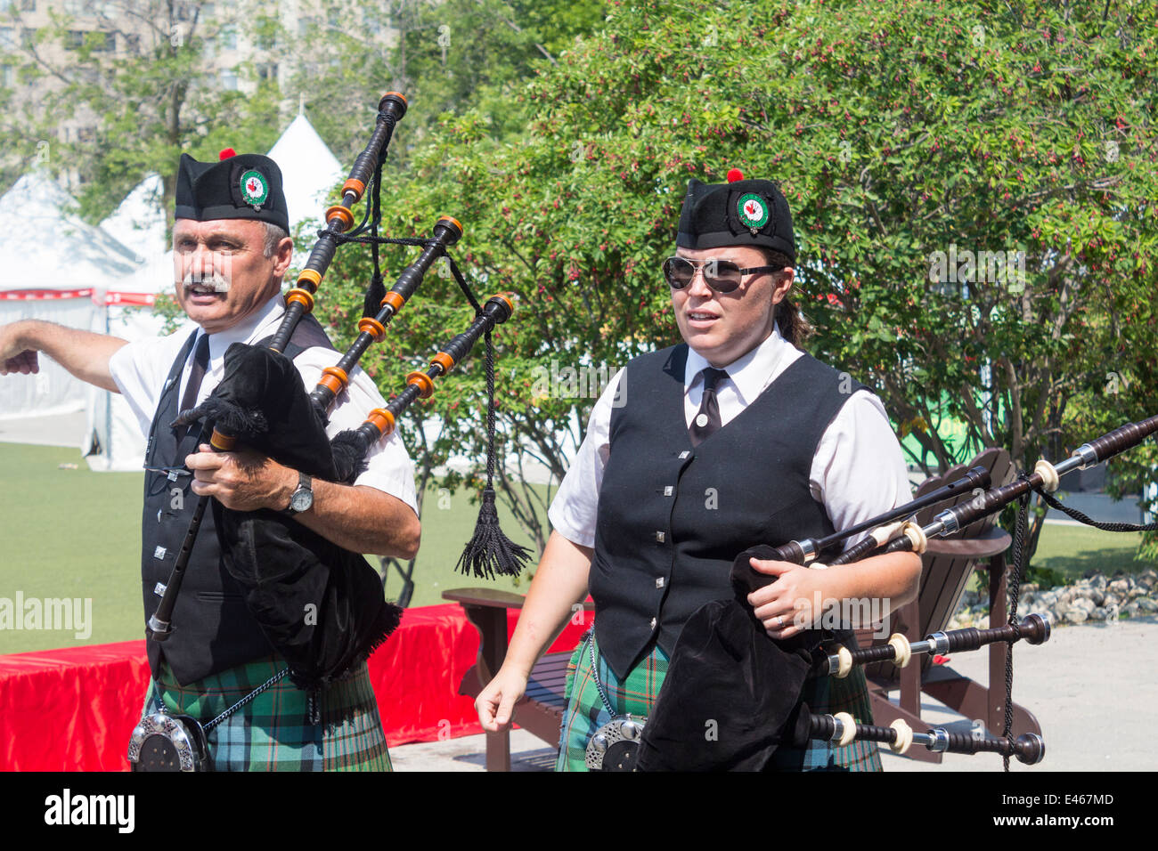 Male and female bagpipe players holding bagpipes for the Dundas Pipes and Drum at Harbourfront for Canada Day Stock Photo