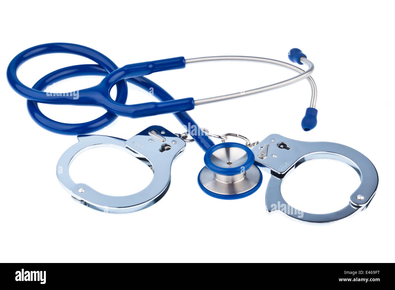 Handcuffs and a stethoscope lying on a white background. Stock Photo