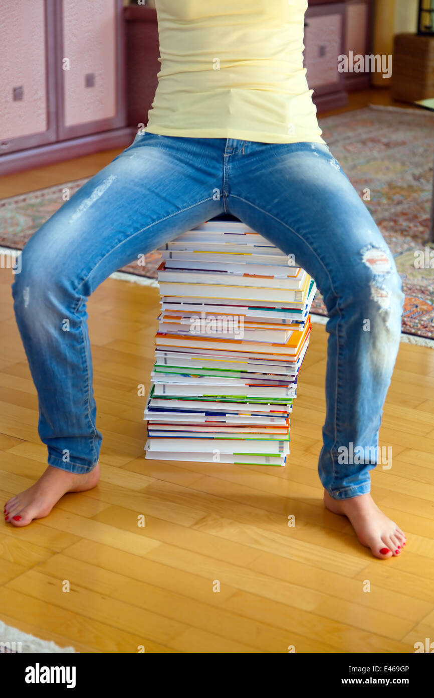 A student sits in front of a stack of books learning Stock Photo