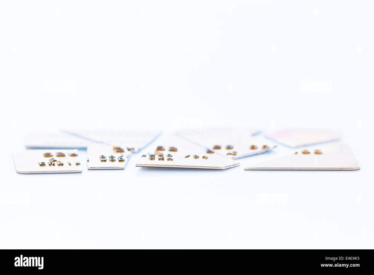 A chopped-up credit card lying on a white background. Symbolic photo for debt. Stock Photo