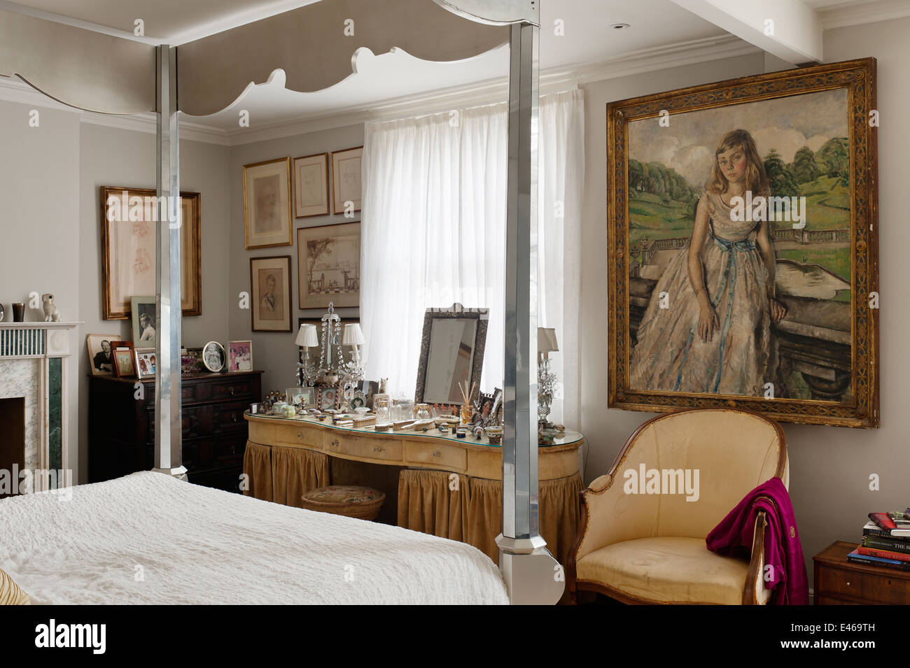 Over-sized dressing table in bedroom with mirrored four poster bed from Julian Chichiest and portrait by Cathleen Mann Stock Photo