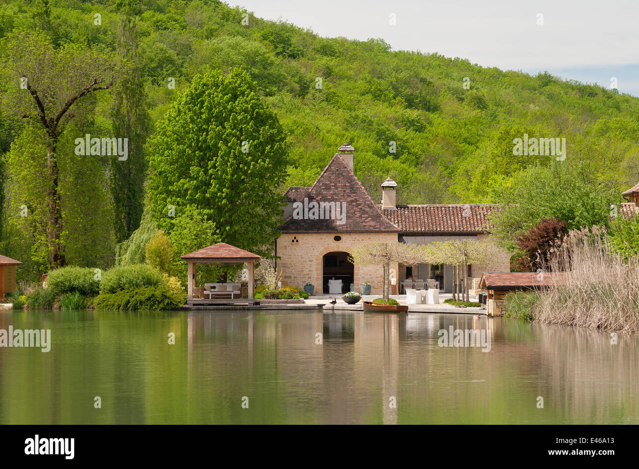 Exterior facade of a 17th century french mill seen from across a small lake Stock Photo