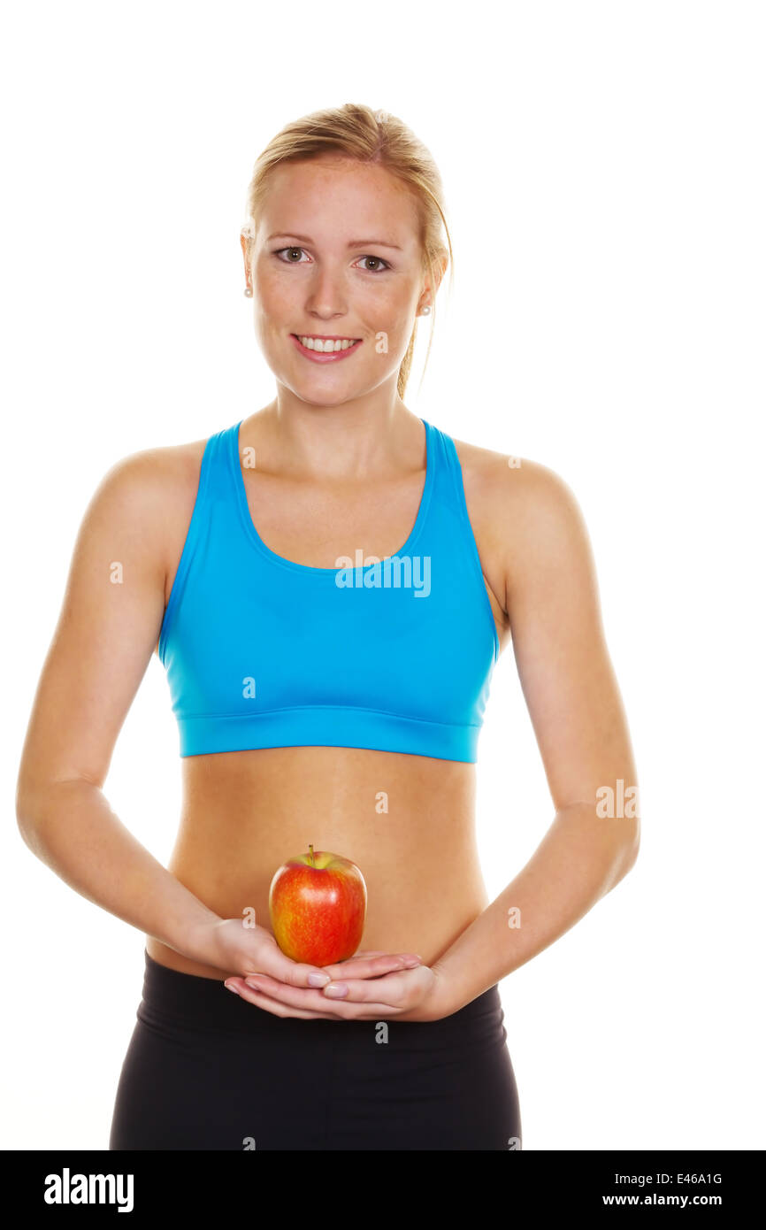 A young woman in sports clothing holding an apple in her hand Stock Photo