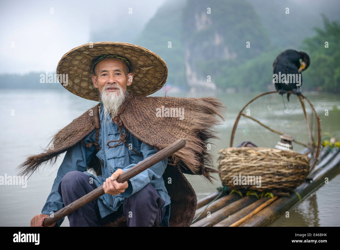 Cormorant fisherman and his bird on the Li River in Yangshuo, Guangxi