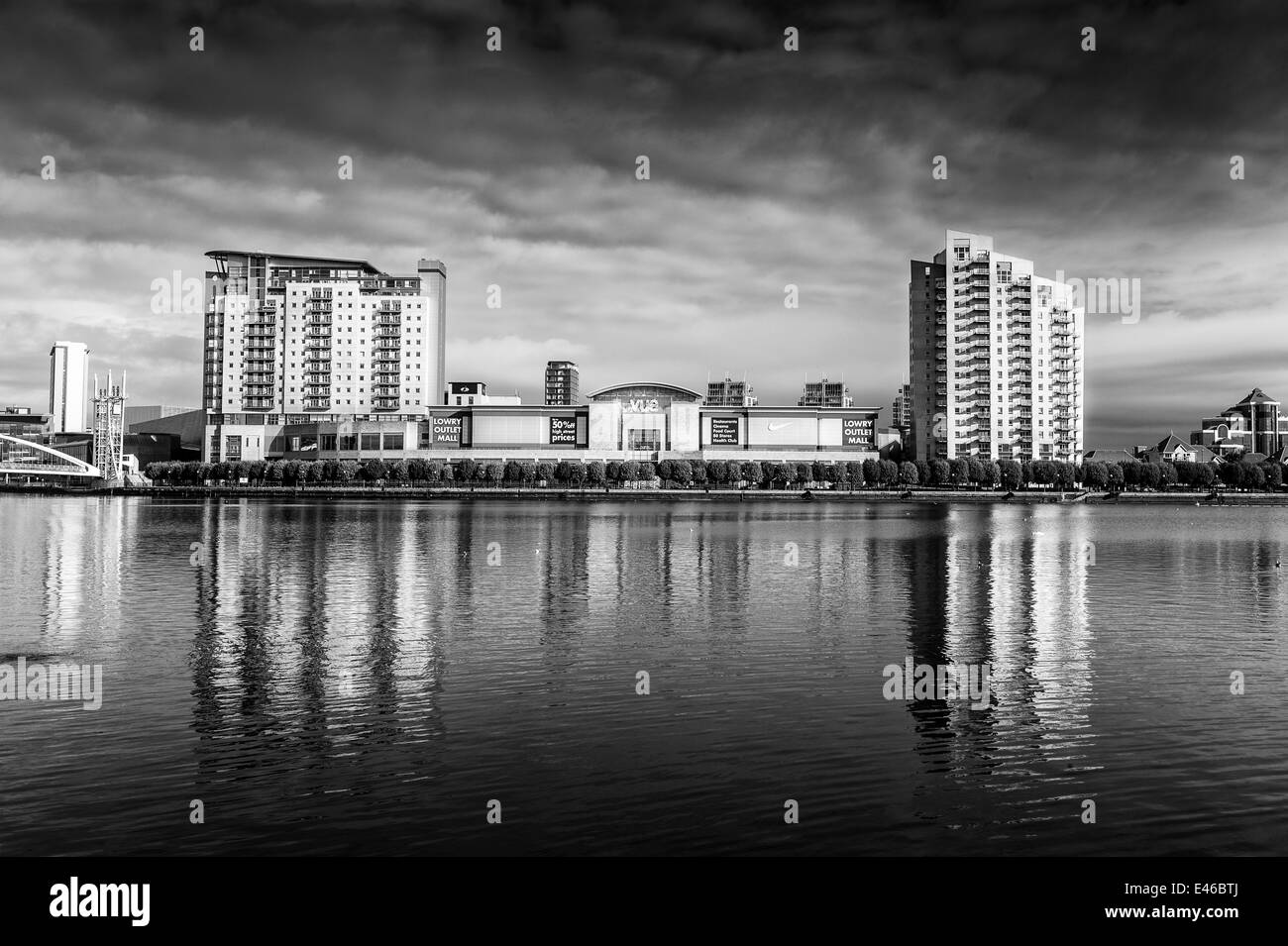 Black and white photo, View across Manchester ship canal of Lowry Outlet, Mall shopping, centre, Salford Quays, Manchester Stock Photo