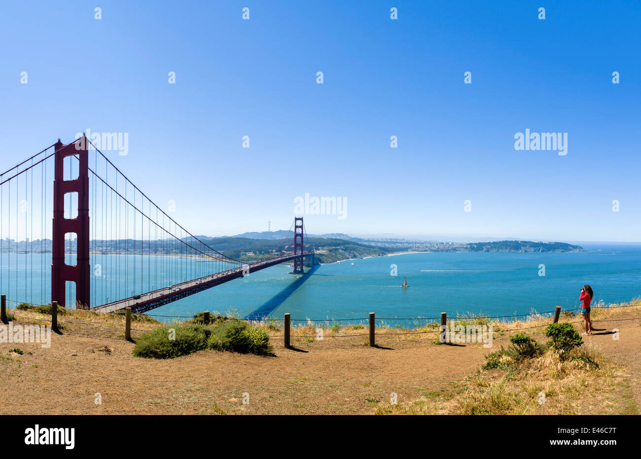 Woman taking a photo of the Golden Gate Bridge from Battery Spencer on the Marin Headlands, San Francisco, California, USA Stock Photo