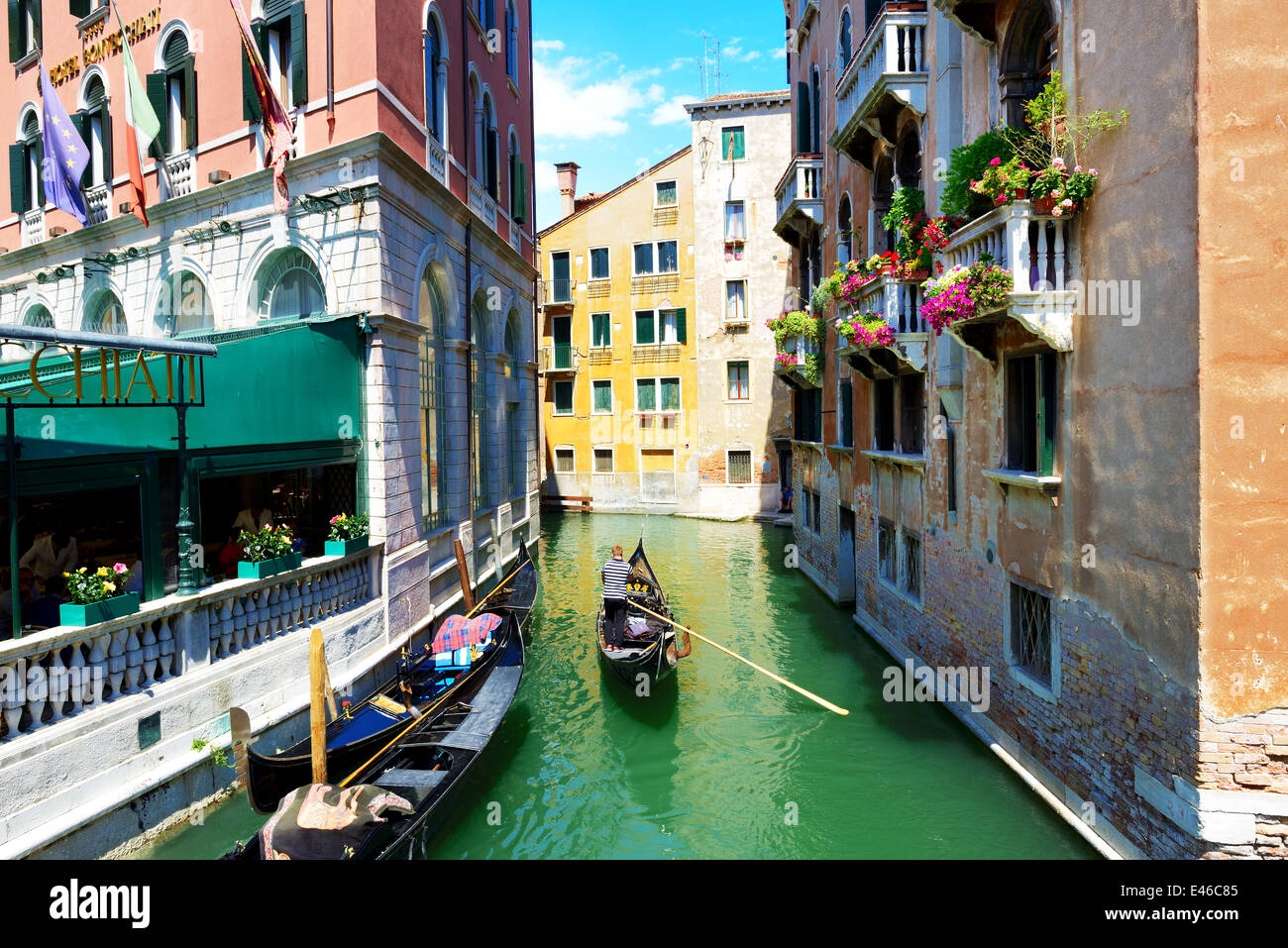 The gondola with tourists is on water channel, Venice, Italy Stock Photo