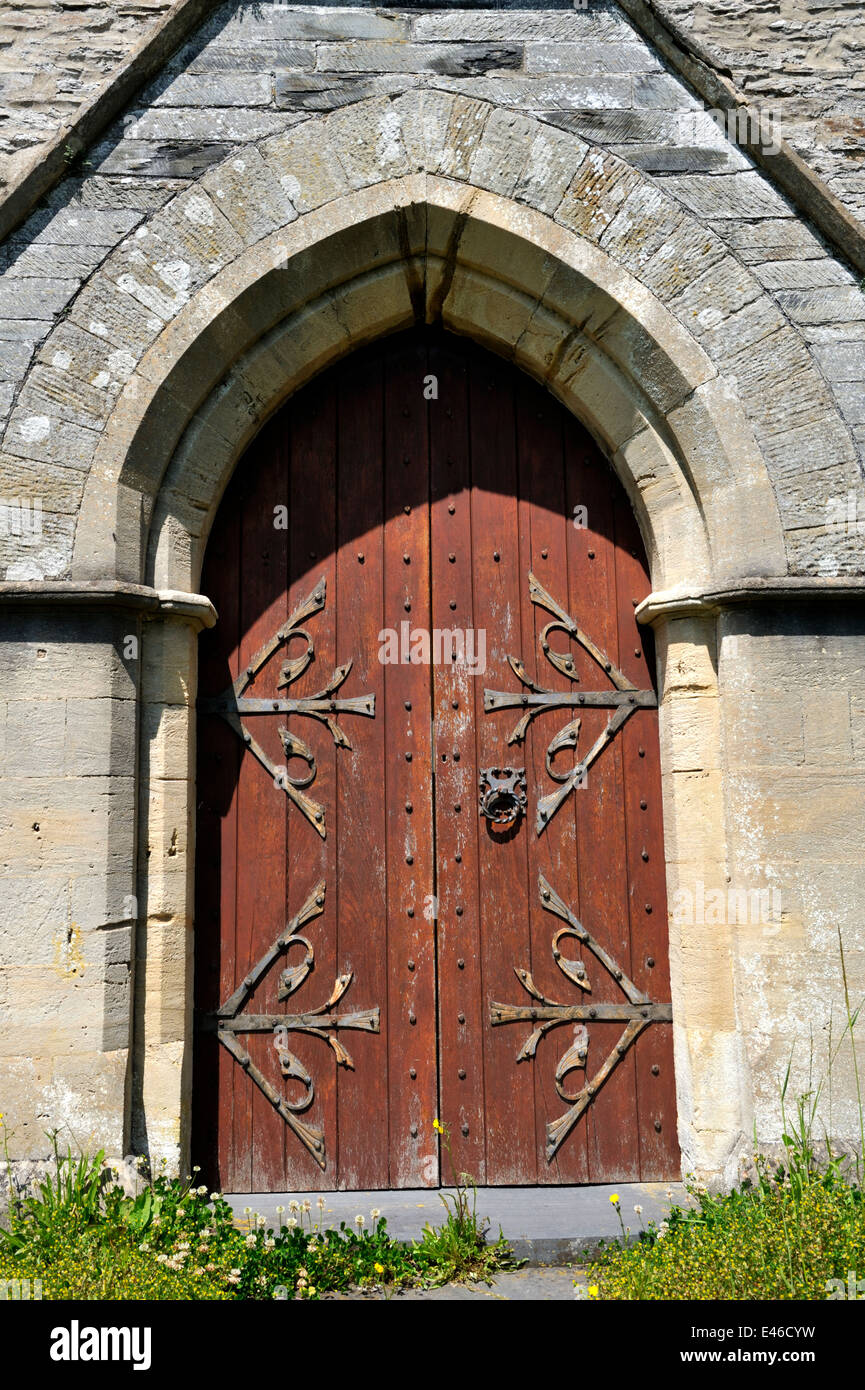 Old wooden door of church with decorative hinges, Molygrove, Pembrokeshire, Wales, UK Stock Photo