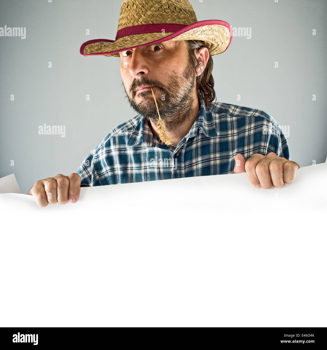 Farmer with cowboy straw hat holding blank poster as copy space Stock Photo