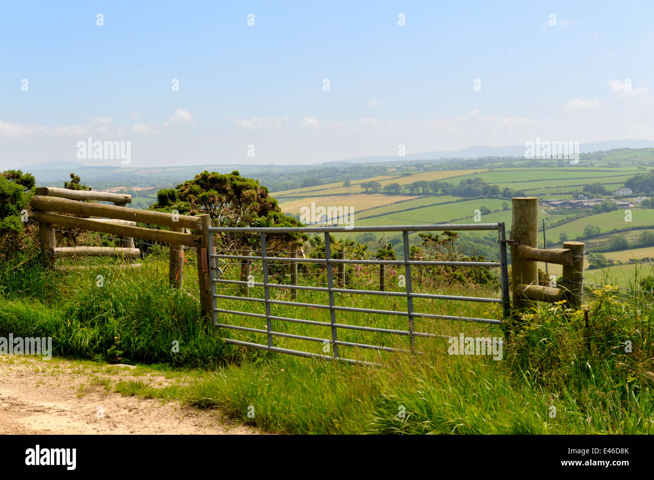 Farm field gate with hazy patchwork of hedgerow bound fields in distance, Wales, UK Stock Photo