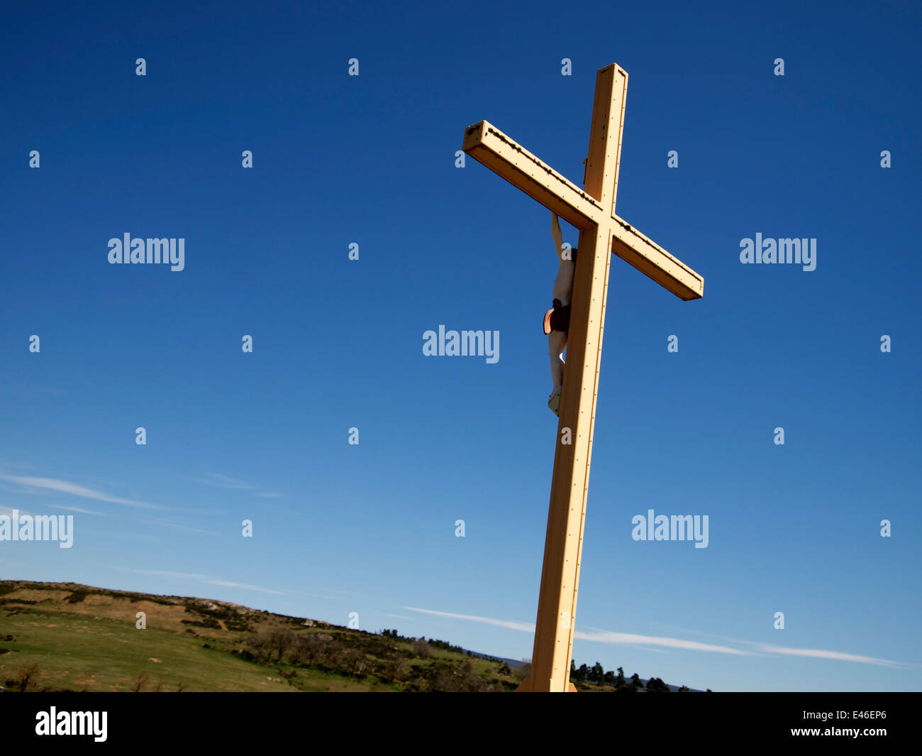 Cross in front of a blue sky in the countryside Stock Photo