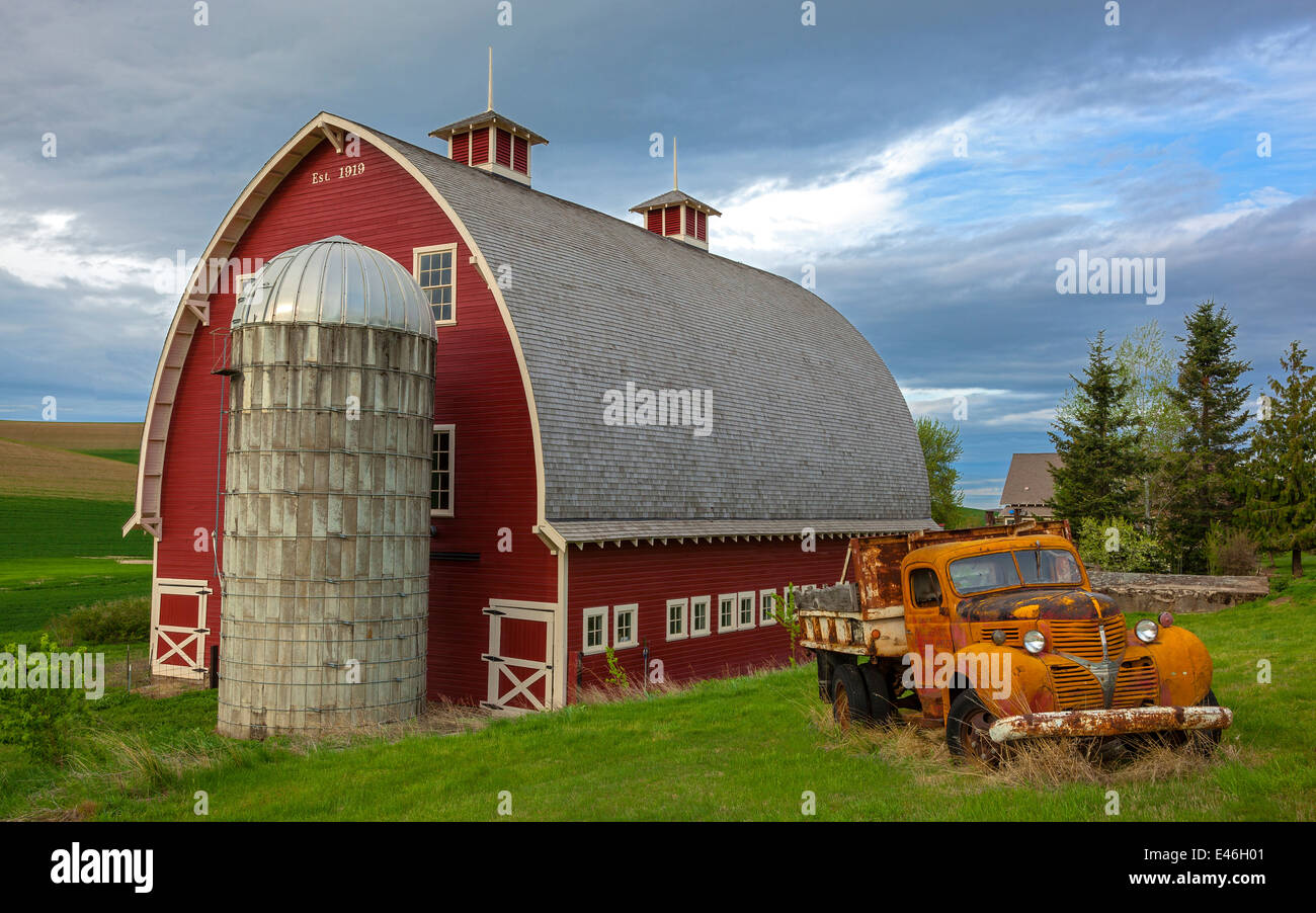 The Palouse, Whitman County, WA: Vintage flatbed truck in front of red barn and silo Stock Photo