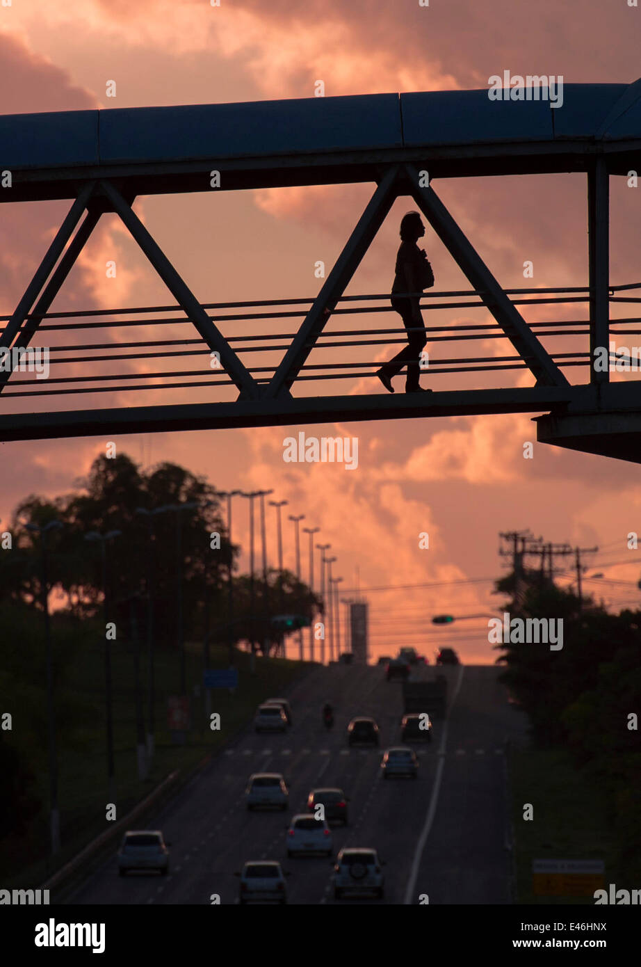 Salvador, Brazil. 3rd July, 2014. A Brazilian is silhouetted by the rising run while walking through a pedestrian bridge in Salvador, Brazil, on July 3, 2014. © Yang Lei/Xinhua/Alamy Live News Stock Photo