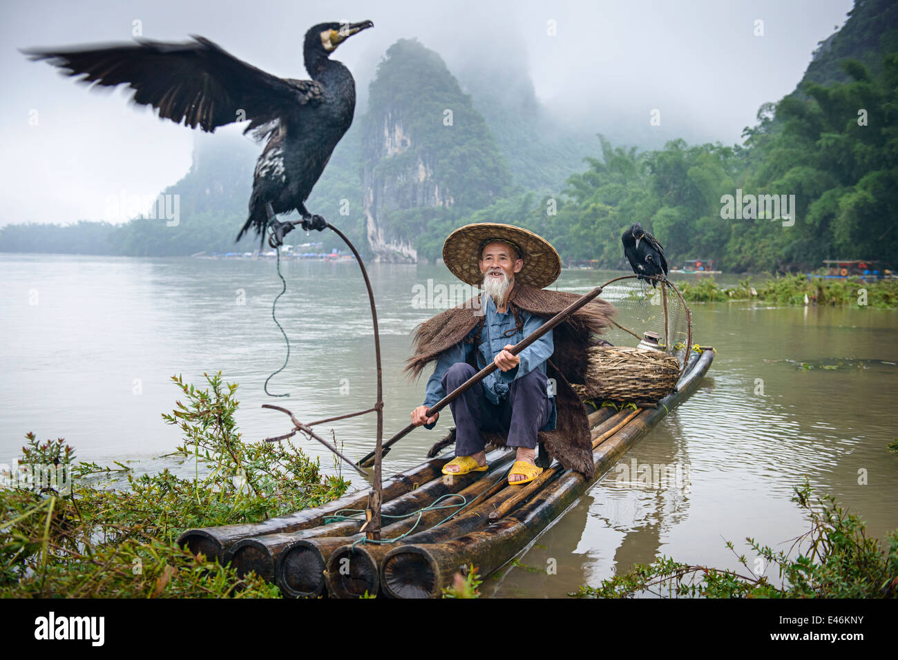 Cormorant fisherman and his bird on the Li River in Yangshuo, Guangxi