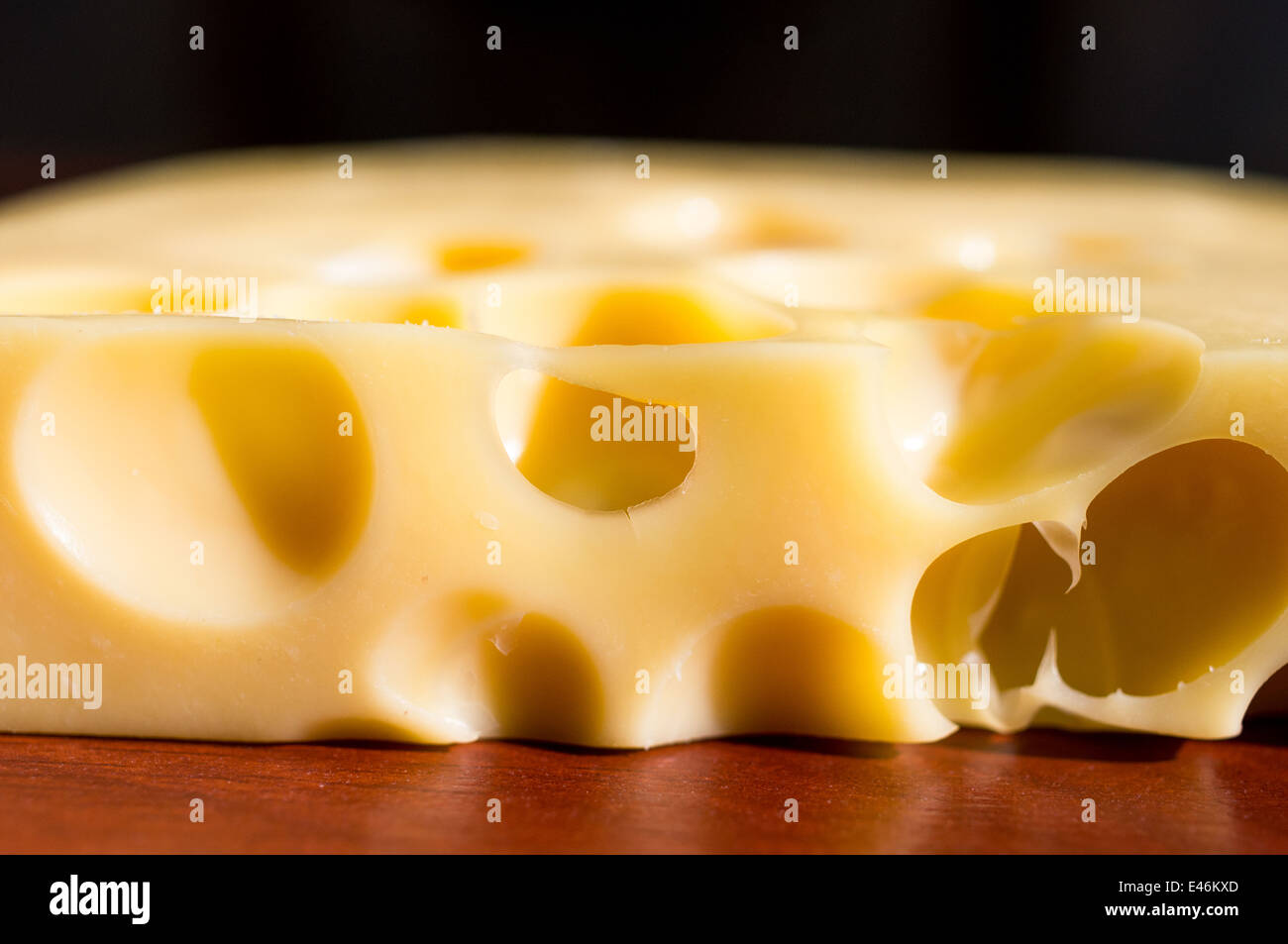 Piece of cheese with holes closeup Stock Photo