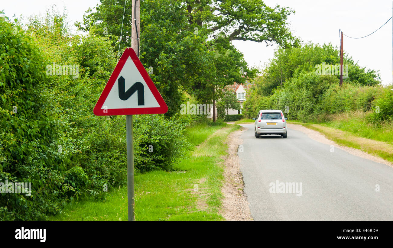 Road sign warning motorists of double bend Stock Photo