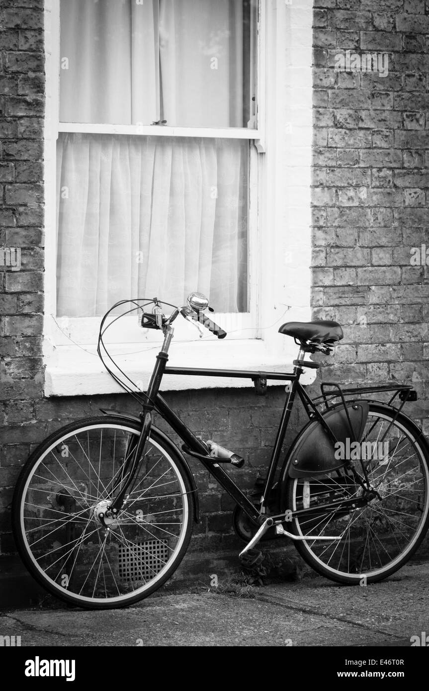 Traditional suffolk scene old bike by the window of a cottage vertical black and white picture Stock Photo
