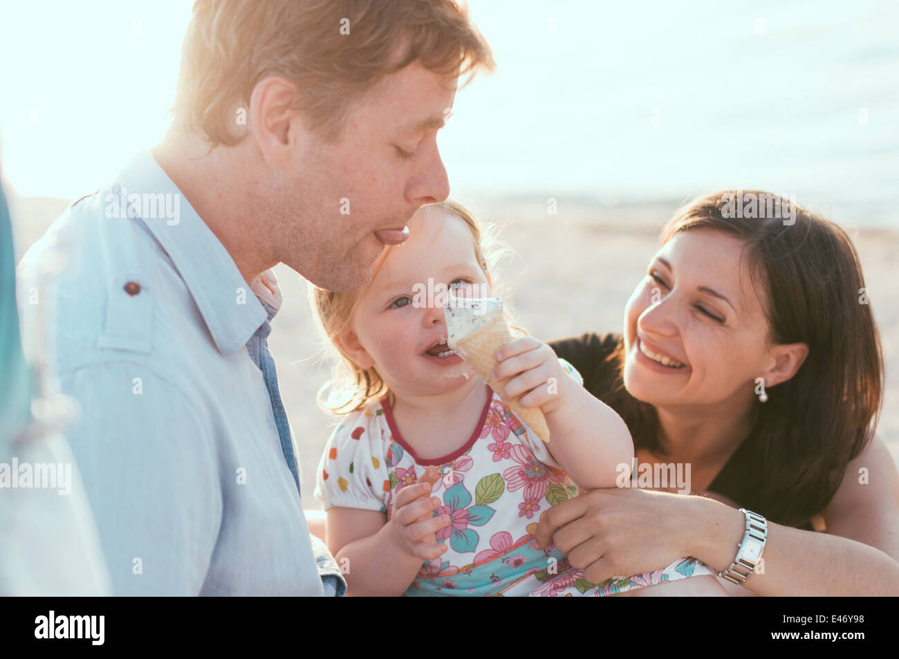 Happy family of three on the beach Stock Photo