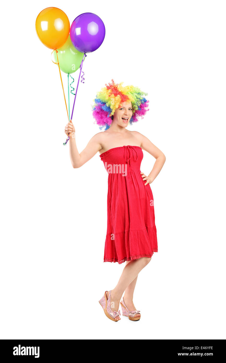 Full length portrait of a girl with wig holding a bunch of balloons Stock Photo