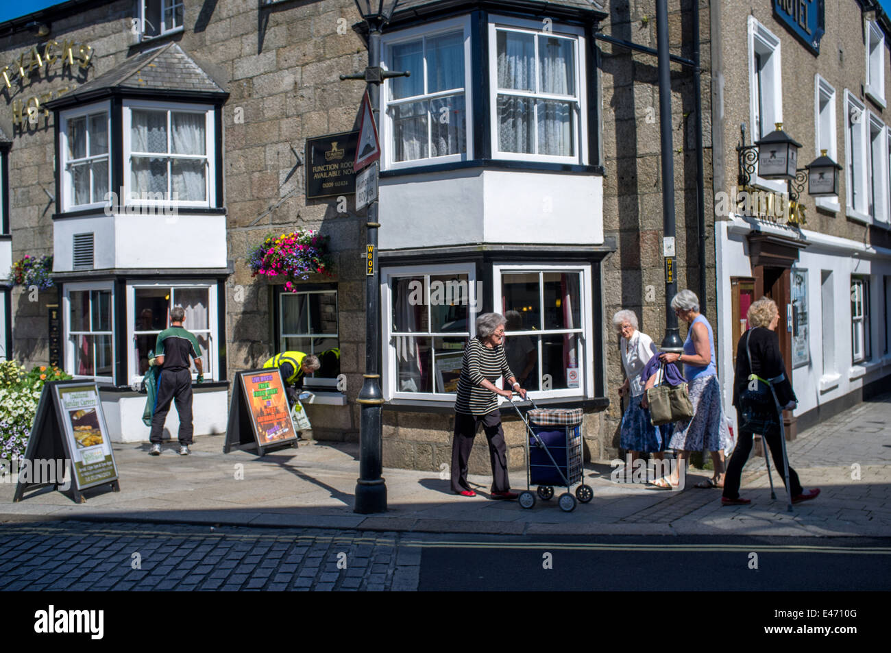 Pensioner walk past a pub in Camborne, Cornwall. The Tyacks Hotel Stock Photo