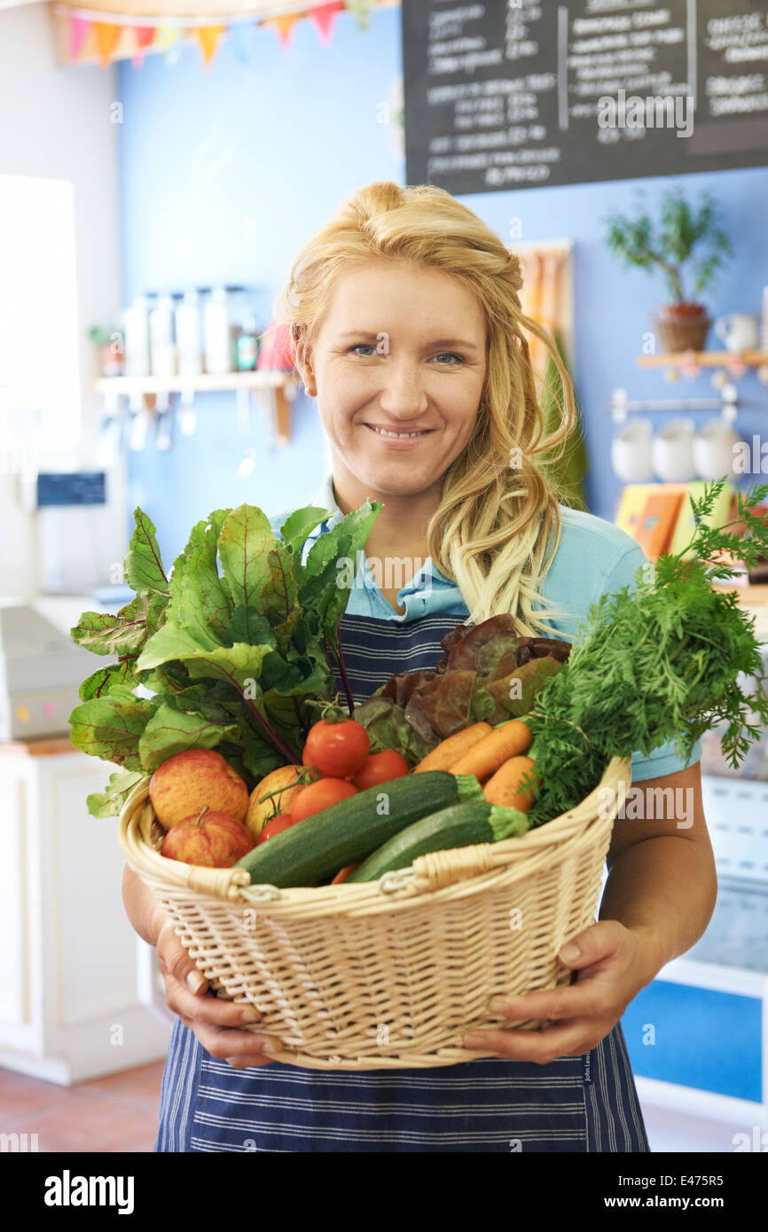 Woman Working In Shop With Basket Of Fresh Produce Stock Photo