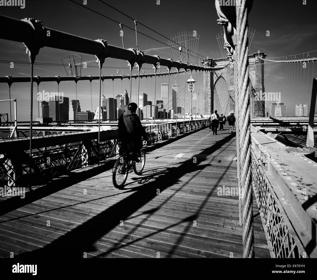 Cyclist on Brooklyn bridge and lower Manhattan skyline prior to September 11 2001 New York City NY USA Stock Photo