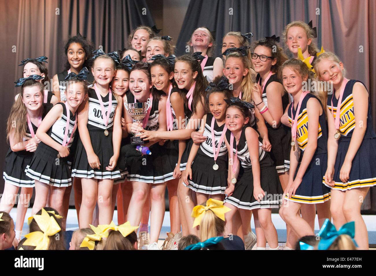 North West London junior cheer leading competition The Wolves winners champions 2014 line up on stage with medals Stock Photo