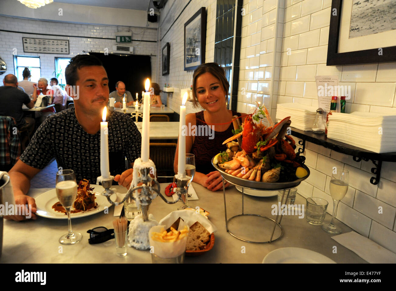 Young couple eating lobster shellfish platter at Riddle and Finns Fish