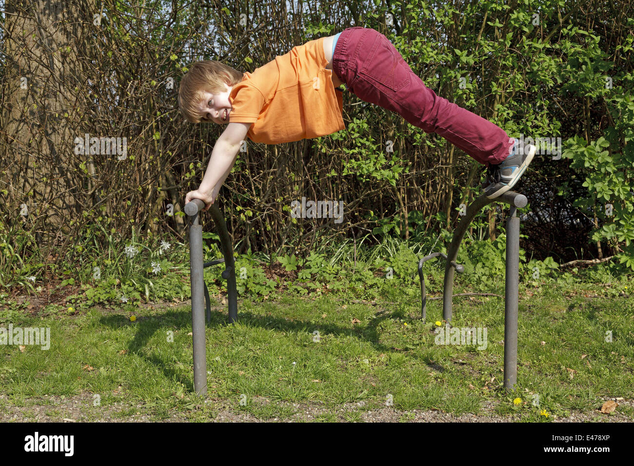 young boy climbing on a bicycle stand Stock Photo