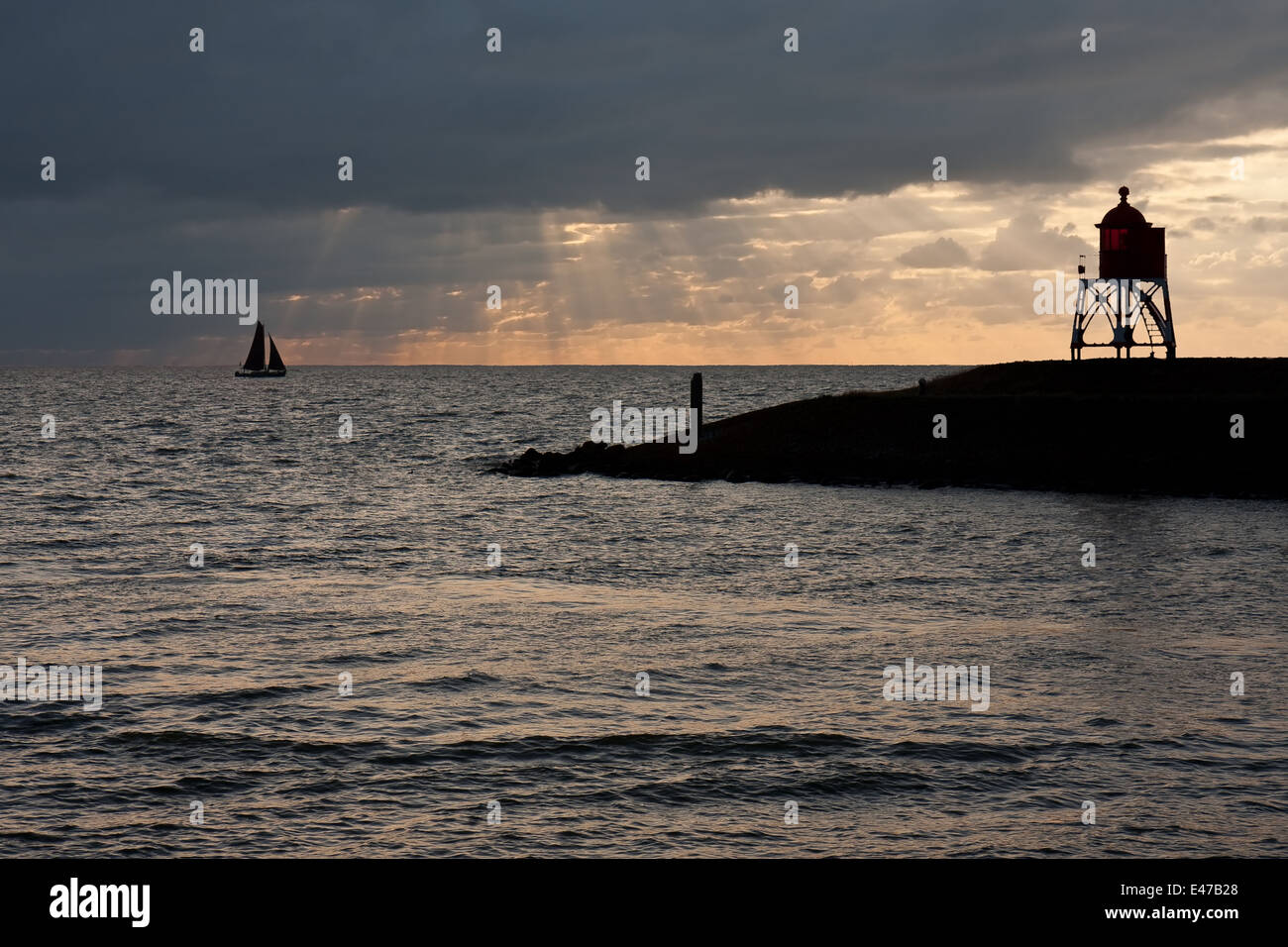 Sailing ship leaving a dutch harbor in the evening Stock Photo