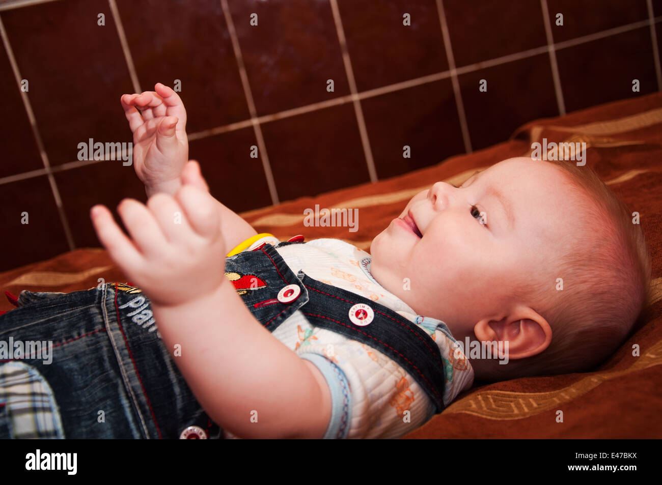 Cute little baby lying on bed and smiling Stock Photo