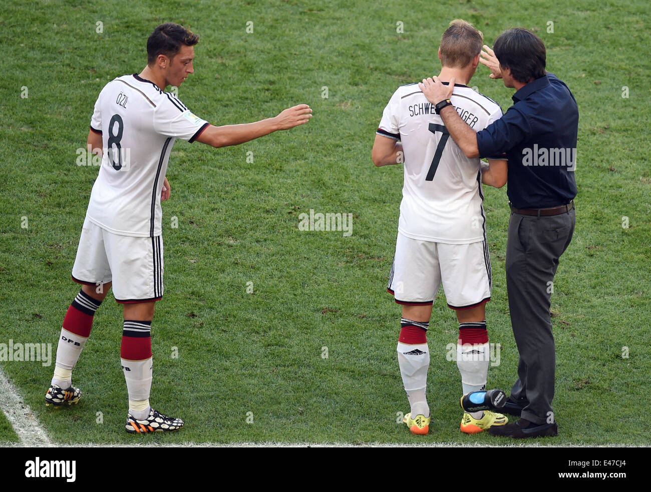 Rio de Janeiro, Brazil. 04th July, 2014. Head coach Joachim Loew (R) of Germany talks to Bastian Schweinsteiger (C) and Mesut Oezil during the FIFA World Cup 2014 quarter final soccer match between France and Germany at Estadio do Maracana in Rio de Janeiro, Brazil, 04 July 2014. Photo: Marcus Brandt/dpa/Alamy Live News Stock Photo