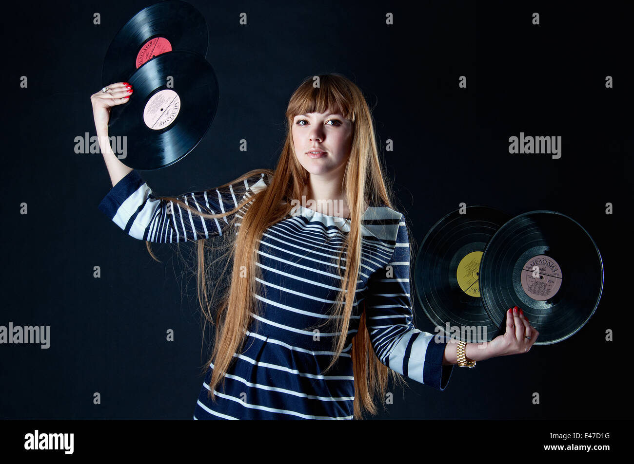 Beautiful blond european holding vinyl discs in her hands, isolated on black Stock Photo