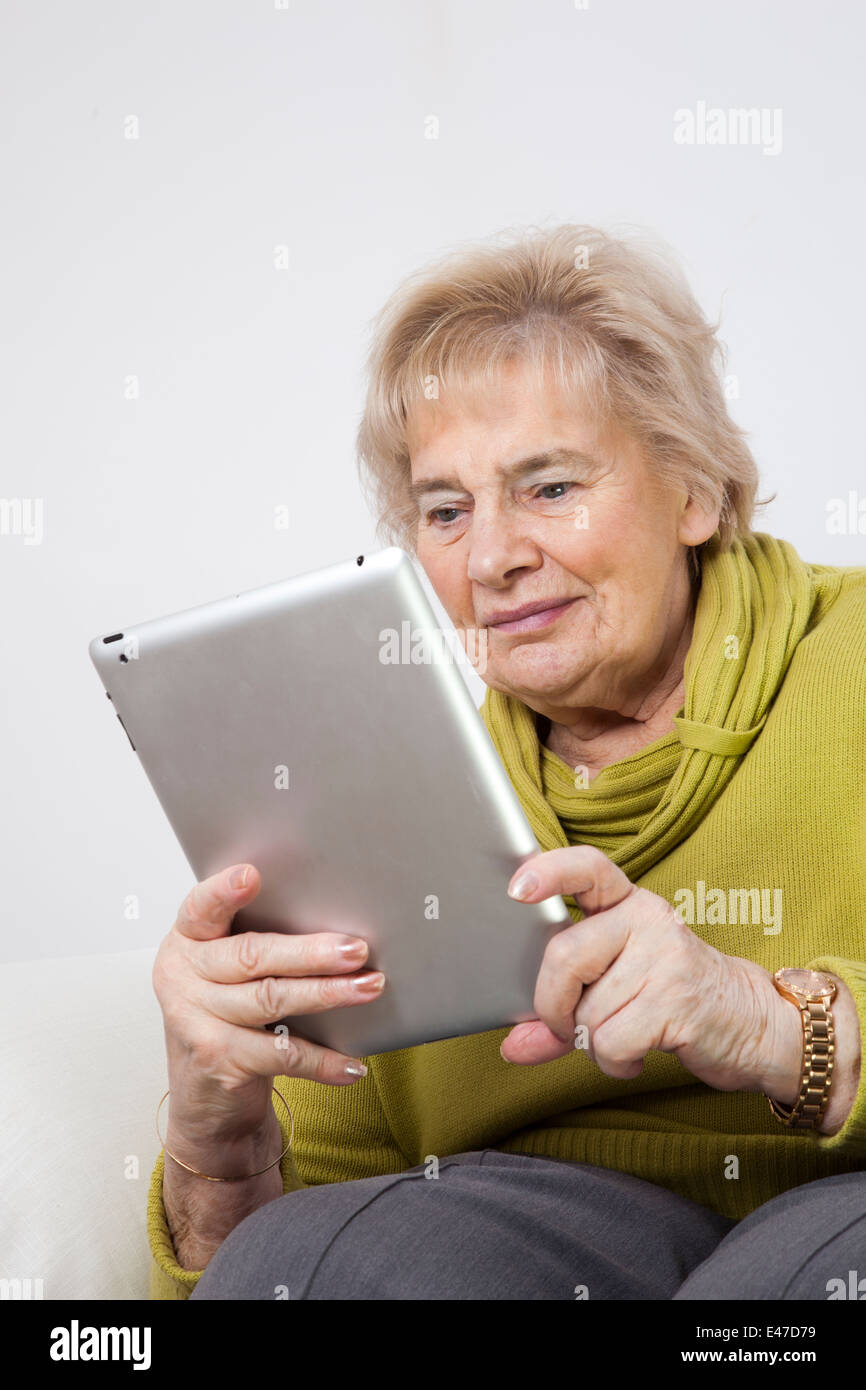 Senior lady looking at a digital tablet (unbranded i-pad) Stock Photo