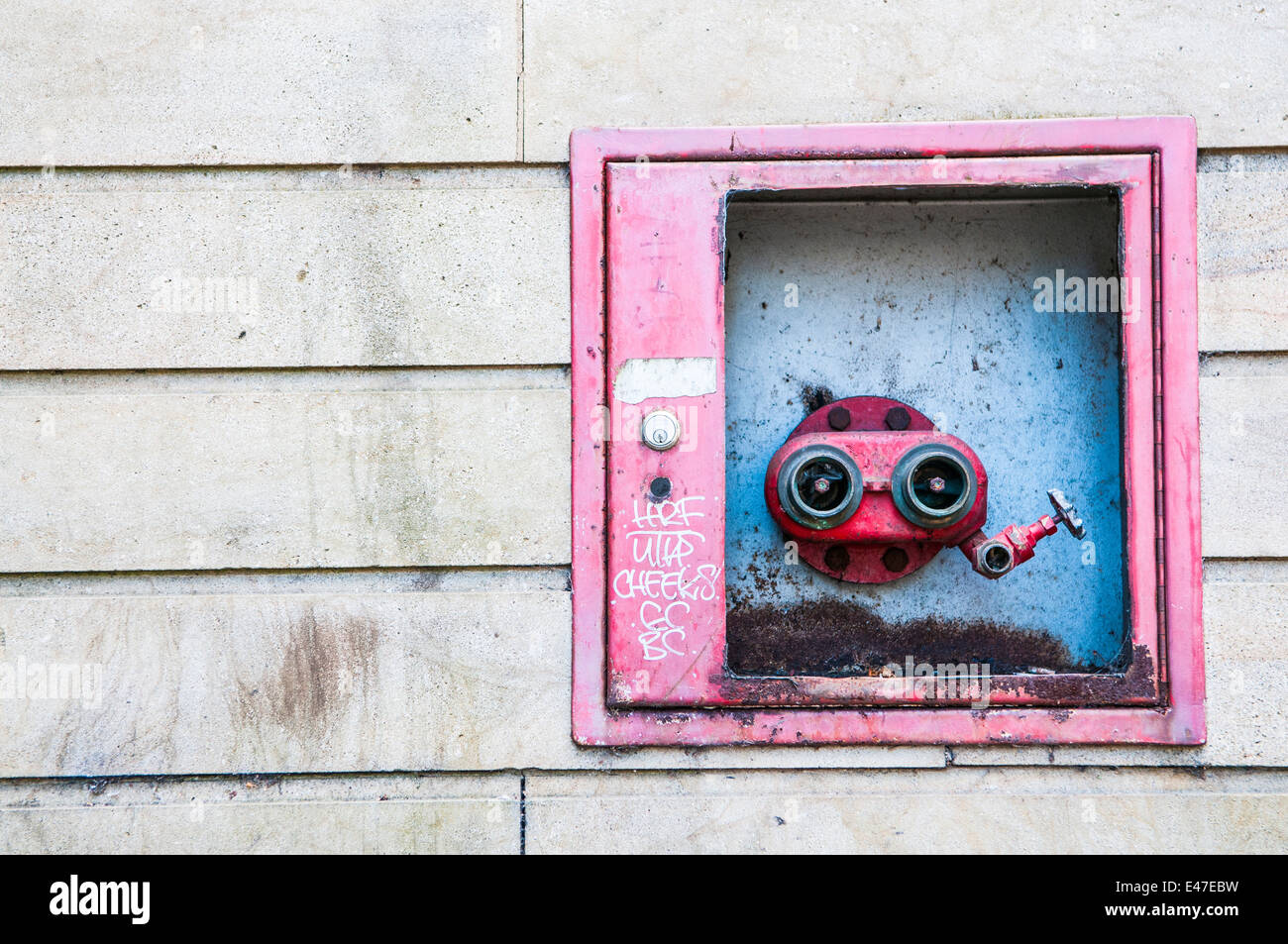Fire hydrant on the side of a building for fire brigade service to use for fire fighting Stock Photo