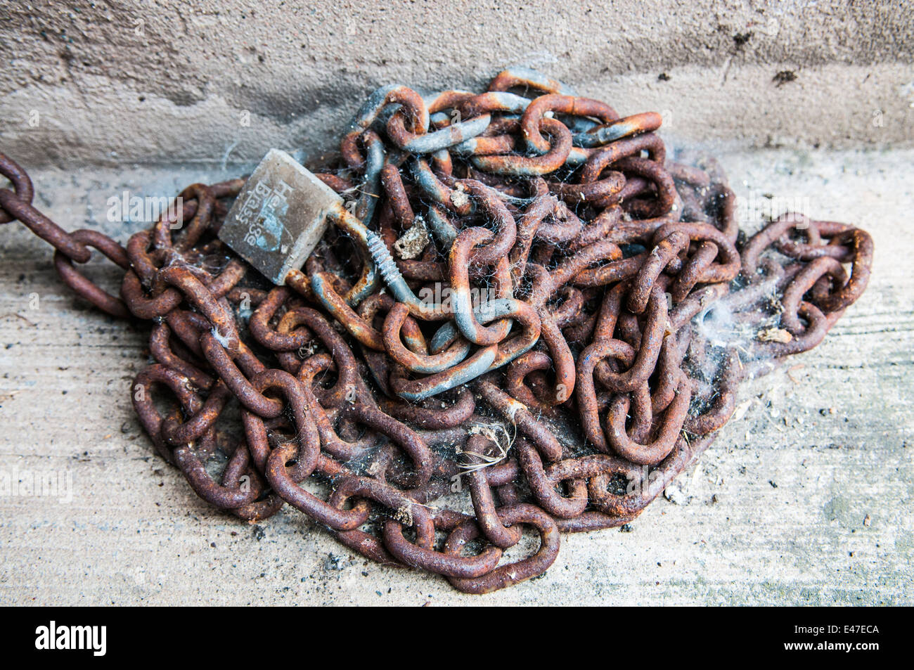 Rusty chain and lock covered with spiders' webs Stock Photo