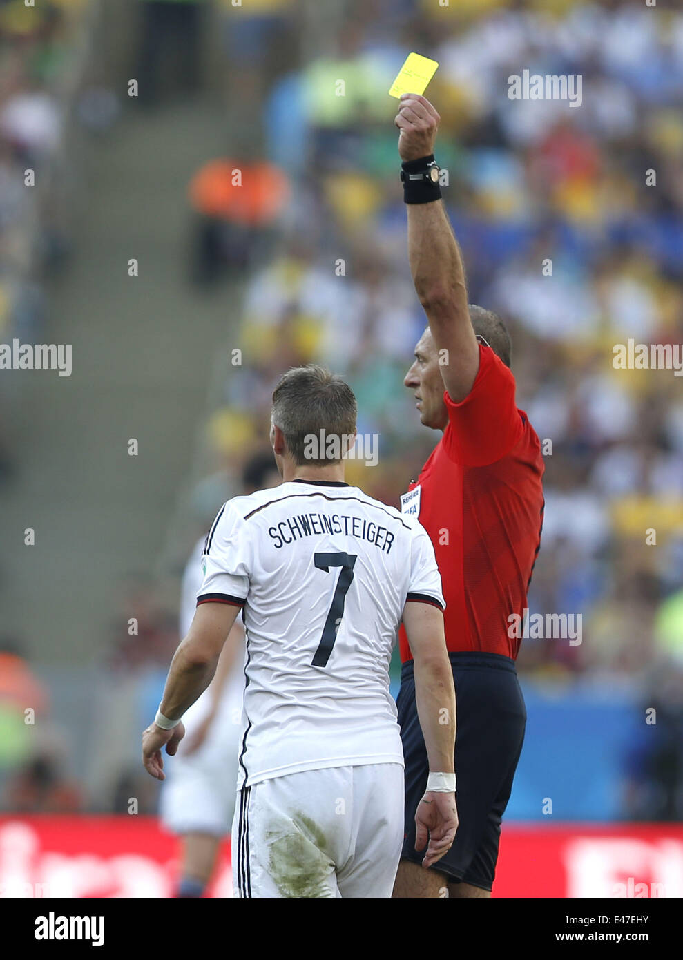 Rio De Janeiro, Brazil. 4th July, 2014. Argentina's referee Nestor Pitana (R) shows a yellow card to Germany's Bastian Schweinsteiger during a quarter-finals match between France and Germany of 2014 FIFA World Cup at the Estadio do Maracana Stadium in Rio de Janeiro, Brazil, on July 4, 2014. Germany won 1-0 over France and qualified for semi-finals on Friday. Credit:  Wang Lili/Xinhua/Alamy Live News Stock Photo
