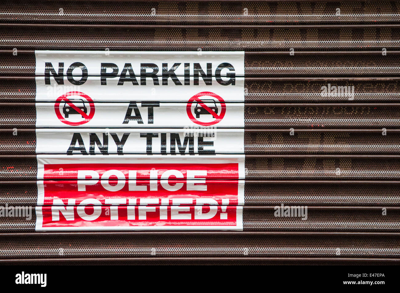 Sign on a shop shutter 'No Parking at any time. Police Notified!' Stock Photo