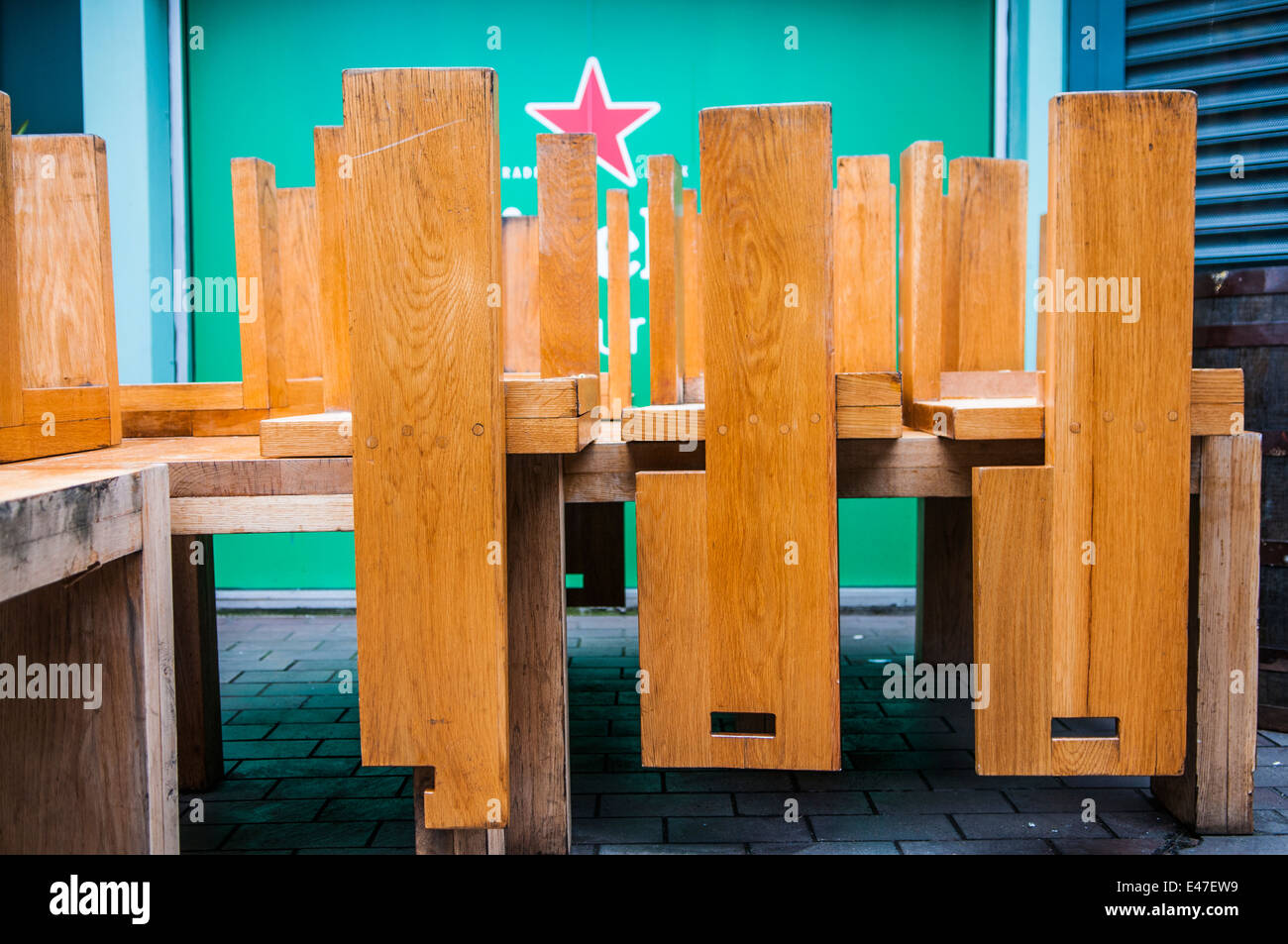 Wooden chairs stacked upside down on tables outside a pub. Stock Photo
