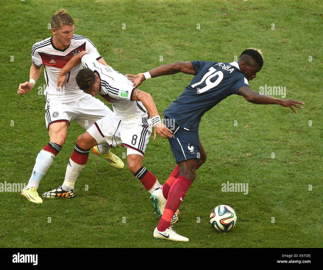 Rio de Janeiro, Brazil. 04th July, 2014. Bastian Schweinsteiger (L) and Mesut Oezil (C) of Germany vie for the ball with Paul Pogba of France during the FIFA World Cup 2014 quarter final soccer match between France and Germany at Estadio do Maracana in Rio de Janeiro, Brazil, 04 July 2014. Photo: Marcus Brandt/dpa/Alamy Live News Stock Photo