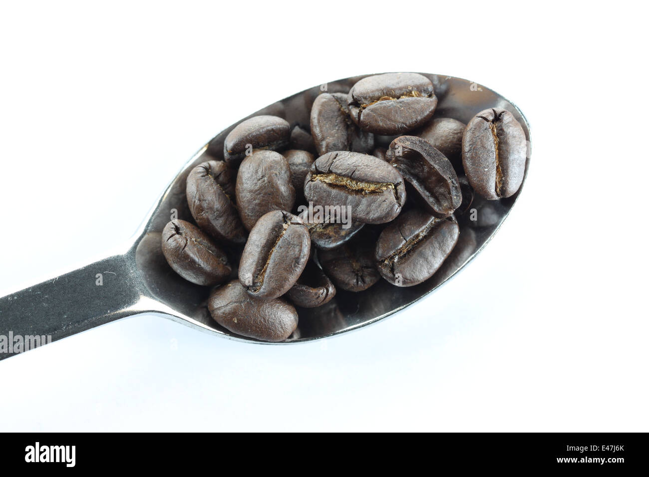 Coffee beans in a stainless steel spoon on white background Stock Photo ...