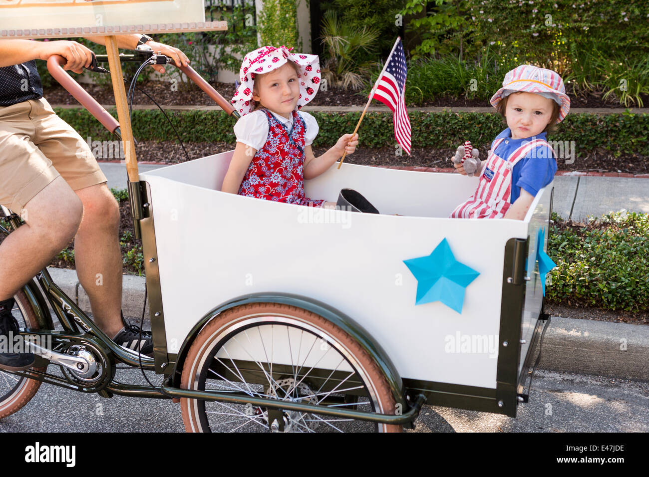 A young family dressed in patriotic costume ride in a bike cart during the I'On community Independence Day parade July 4, 2014 in Mt Pleasant, South Carolina. Stock Photo