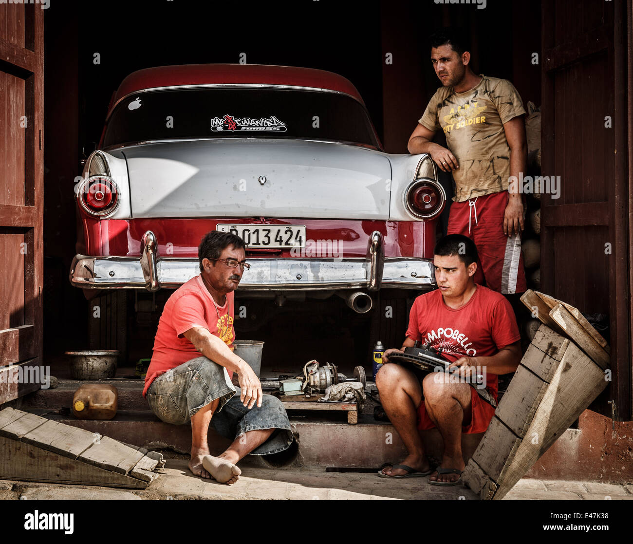 Three man fixing an oldtimer car, Trinidad, Cuba Stock Photo