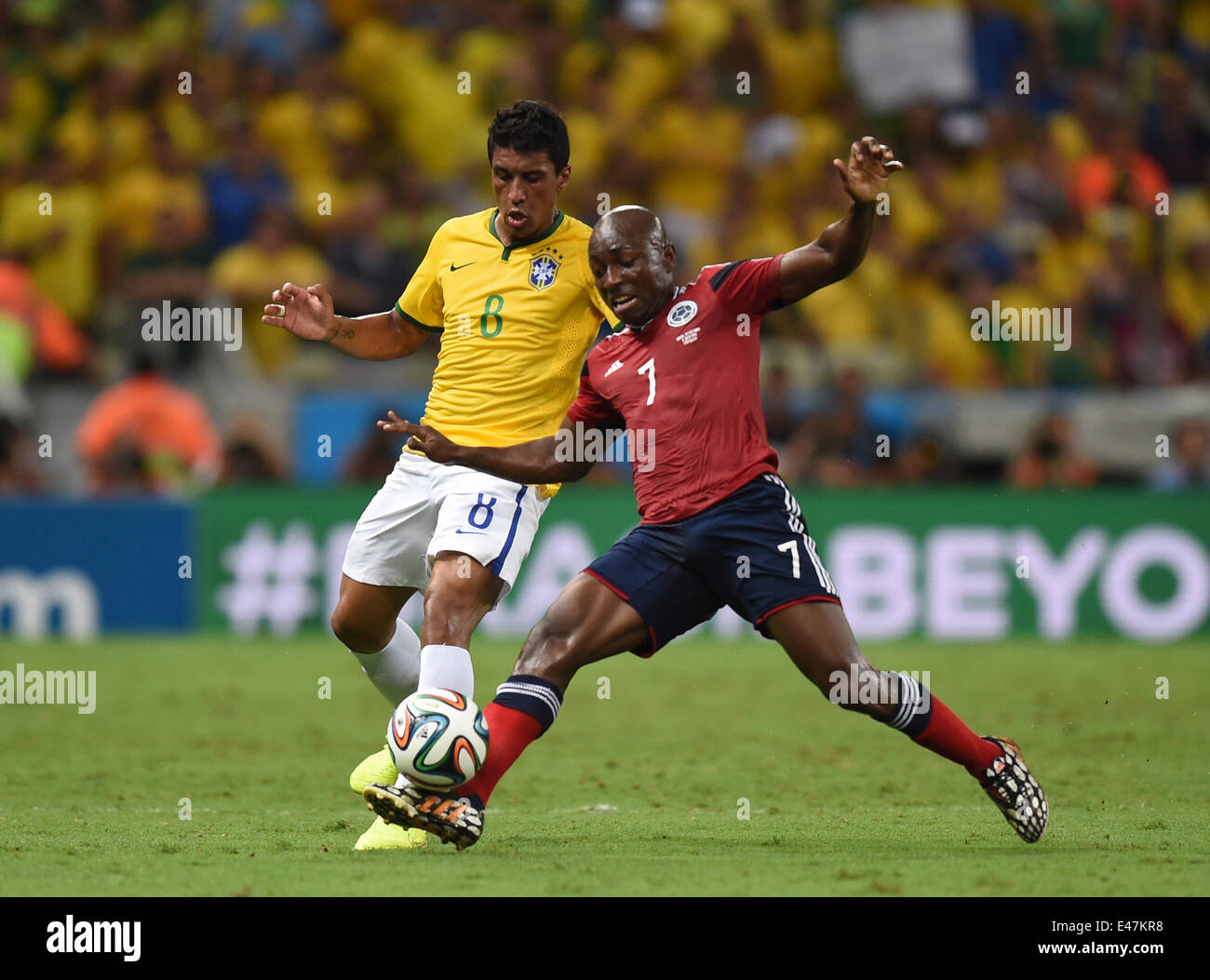 Fortaleza, Brazil. 04th July, 2014. Paulinho (L) of Brazil and Pablo Armero of Colombia vie for the ball during the FIFA World Cup 2014 quarter final match soccer between Brazil and Colombia at the Estadio Castelao in Fortaleza, Brazil, 04 July 2014. Photo: Marius Becker/dpa/Alamy Live News Stock Photo