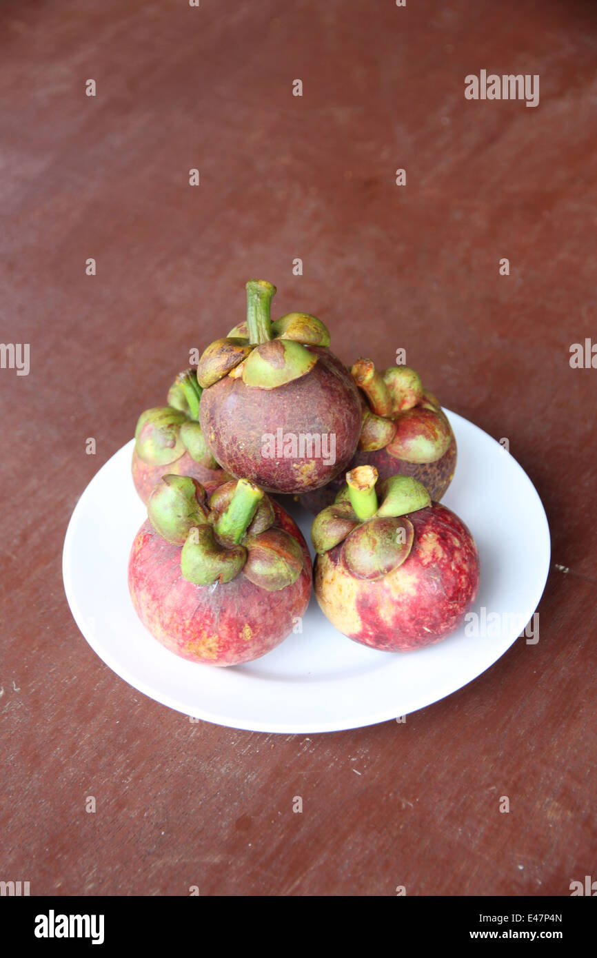 Fresh mangosteen fruit in dish on the foods table. Stock Photo