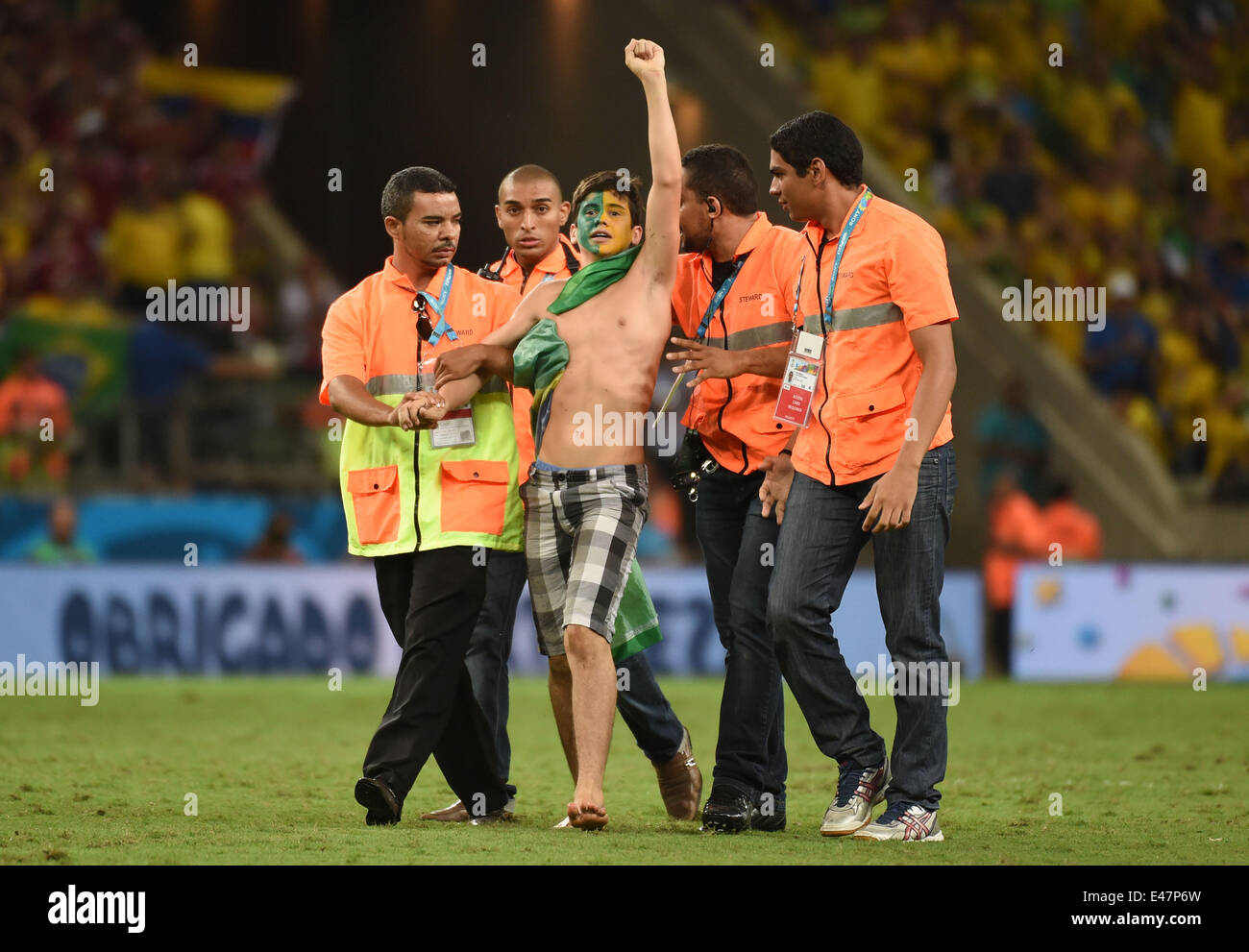 Fortaleza, Brazil. 4th July, 2014. Security members drag off a fan who runs into the field after a quarter-finals match between Brazil and Colombia of 2014 FIFA World Cup at the Estadio Castelao Stadium in Fortaleza, Brazil, on July 4, 2014. Brazil won 2-1 over Colombia and qualified for semi-finals on Friday. Credit:  Li Ga/Xinhua/Alamy Live News Stock Photo