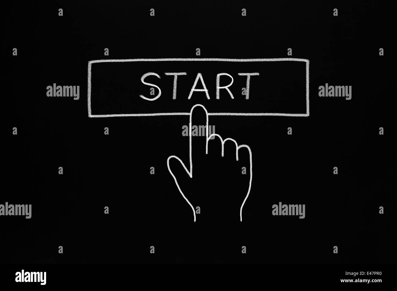 Hand clicking Start button drawn with white chalk on blackboard. Stock Photo