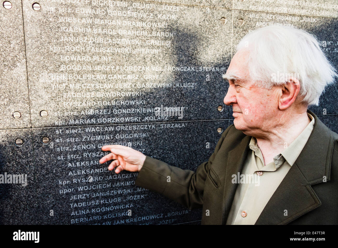 WWII veteran Zygmunt Gwiazdowski pointing to his brother Zenon name, deceased at a concentration camp. Warsaw uprising museum Stock Photo