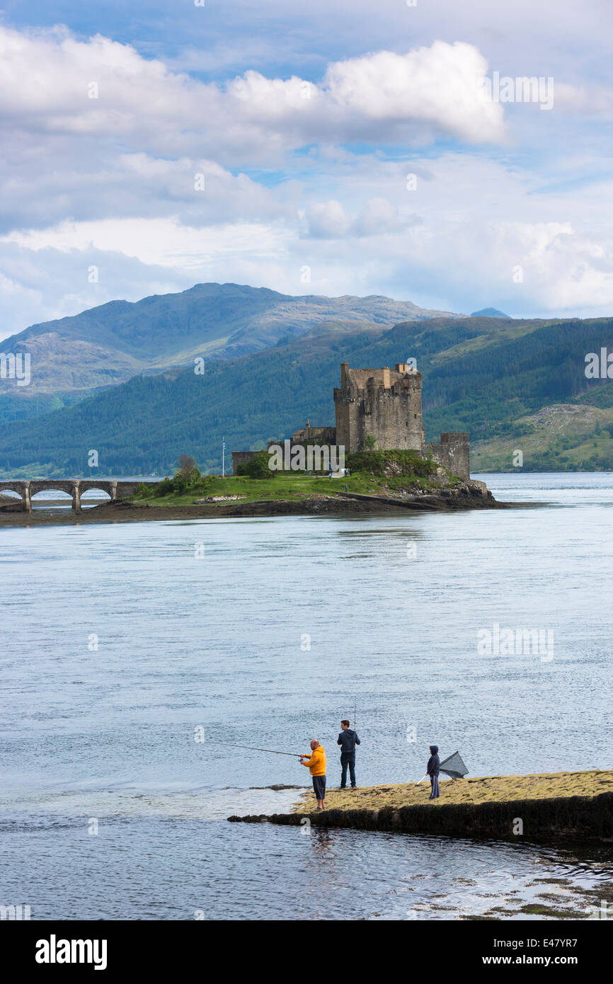 Locals fishing by Eilean Donan Castle, 13th Century fortress of MacRae clan, in Loch Alshe, HIghlands of SCOTLAND Stock Photo